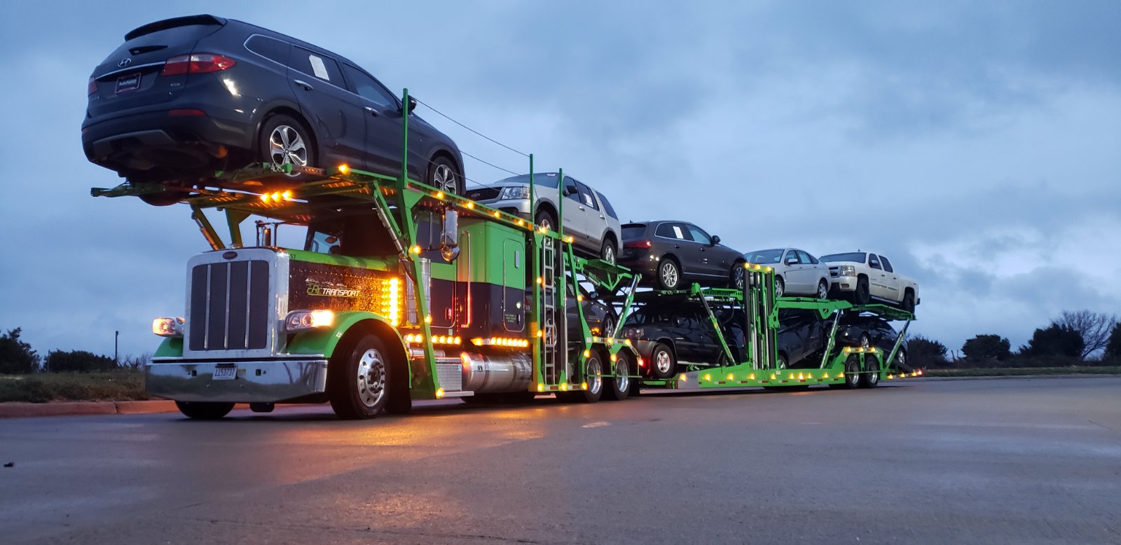 green car hauler with 9 cars